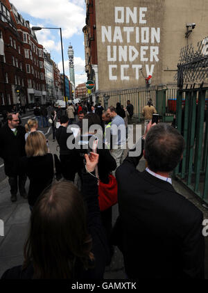 Les gens qui regardent une nouvelle œuvre Graffiti, prétendument par l'artiste basé à Bristol 'Banksy' dans la cour d'un dépôt Royal Mail à Newman Street, dans le centre de Londres. Banque D'Images