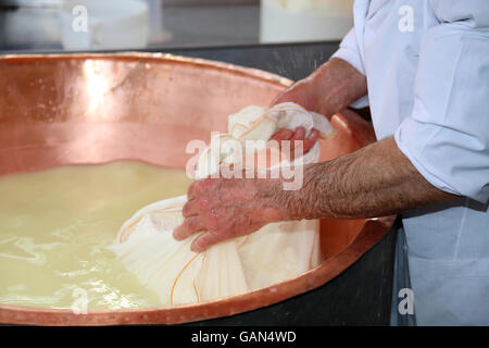 Senior expert fromager collecte le fromage avec la toile de la grande vasque en cuivre rempli de lait et lactosérum Banque D'Images