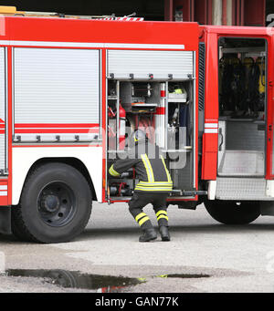 Les tuyaux d'eau prépare des pompiers pour éteindre le feu lors d'un exercice d'entraînement Banque D'Images