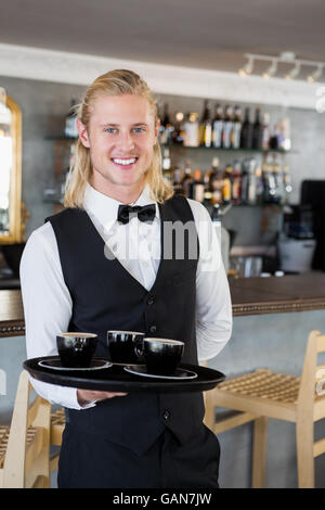 Waiter holding un plateau avec les tasses de café dans le Banque D'Images