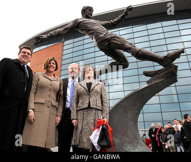Brian Barwick, chef de la direction de la FA, dévoile une statue d'Emlyn Hughes, avec l'ancienne femme d'Emlyn Barbara Hughes (à droite), la fille Emma (à gauche) et son Emlyn (à gauche) à l'extérieur de l'édifice Emlyn Hughes à Barrow, dans Furness. Banque D'Images