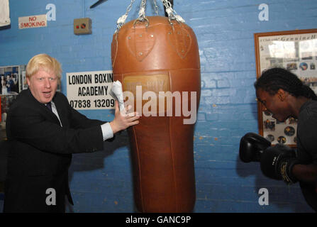 Le candidat conservateur du maire de Londres Boris Johnson détient un sac de punch pour Chavez Campbell lors d'une visite au projet communautaire de la London Boxing Academy à Tottenham, dans le nord de Londres. Banque D'Images