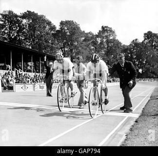 Cyclisme - Jeux Olympiques de Londres 1948 - hommes 1000m scratch - Herne Hill.Clodomiro Cortoni (l) en Argentine et J Hoid (r) aux États-Unis mettent leur chaleur en marche alors que le lanceur (arrière-plan) allume son pistolet Banque D'Images