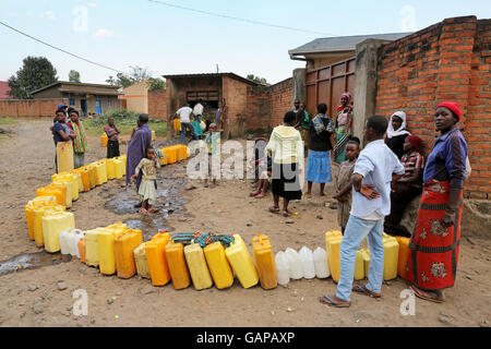 Une longue ligne de colis en attente d'être comblé à un point d'eau public à Ruhengeri, Rwanda, Afrique du Sud Banque D'Images