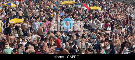 Une plage pleine de monde à Brighton, dans le Sussex, tandis que les gens apprécient le temps chaud lors de ce qui devrait être le jour le plus chaud de l'année jusqu'à présent. Banque D'Images