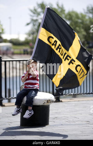 Le jeune fan de Cardiff, Noah Pritchard, 2 ans, fait passer un drapeau à l'appui de son équipe à Plass Roald Dahl, Cardiff. Banque D'Images
