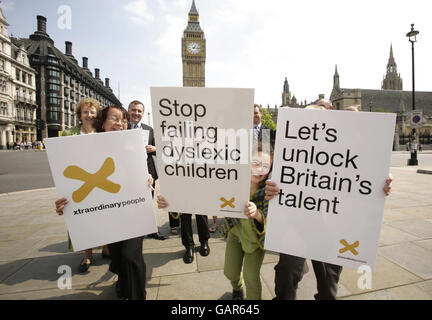 Les militants de la place du Parlement (y compris les députés de tous les partis politiques) et Cara Abraham (au centre), un écolier de Southwark avec dyslexie devant le Parlement dans le centre de Londres, Avant de présenter un « rapport de fin d'études » à Downing Street, qui les exhorte à accélérer leur soutien ou les enfants dyslexiques et leurs familles à la suite d'une série de rapports accablants de la charité de dyslexie Xtraordinary People. Banque D'Images