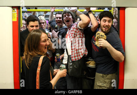 Les fêtards boivent sur un train tube Circle Line, avant que l'interdiction de boire de l'alcool n'entre en vigueur à minuit. Banque D'Images