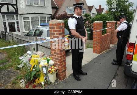 Un policier à l'extérieur du numéro 111, Park Lane, à Carshalton, où un garçon de cinq ans et une fille de quatre ans sont morts après avoir été trouvé avec de graves blessures par coups de couteau et une petite fille de six mois a été grièvement blessée. Banque D'Images