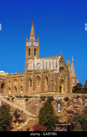 Vue sur l'église néo-gothique datant de 19th ans de notre-Dame de Lourdes - Mgarr, Gozo, Malte. Banque D'Images