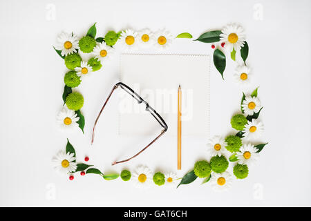 Papier, crayon et verres avec floral frame à partir de camomille et de fleurs de chrysanthème, ficus feuilles et ripe rowan sur white backg Banque D'Images