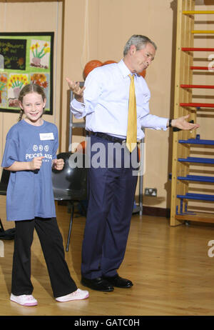 LE président AMÉRICAIN George Bush joue au basket-ball avec des membres du groupe international de basketball PeacePlayers à l'école primaire intégrée de Loughview alors qu'il termine sa visite en Irlande du Nord. Banque D'Images