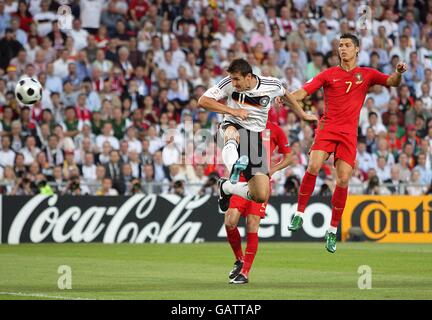 Football - Championnat d'Europe de l'UEFA 2008 - quart de finale - Portugal / Allemagne - St Jakob-Park.Miroslav Klose, en Allemagne, se dirige vers le deuxième but, alors que Cristiano Ronaldo, au Portugal, regarde (r) Banque D'Images