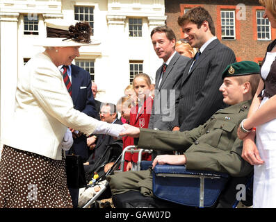 La reine Elizabeth II de Grande-Bretagne, accompagnée du duc d'Édimbourg, s'entretient avec Joseph Townsend, 20 ans, d'Eastbourne, une Marine royale qui a perdu les deux jambes lors de la lecture d'une mine anti-char en Afghanistan en février dernier, à l'hôpital Royal de Chelsea, dans l'ouest de Londres, cet après-midi. Banque D'Images