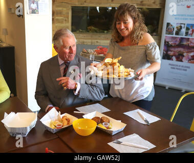 Le Prince de Galles à un poisson et chip shop dans le village d'Aberdaron le deuxième jour de leur visite d'été annuel au Pays de Galles. Banque D'Images