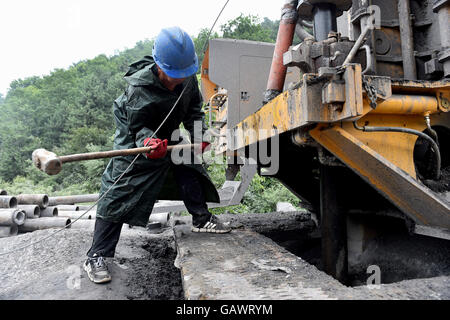 Qinshui, la province de Shanxi. 5 juillet, 2016. Un sauveteur qui frappe une canalisation à une mine de charbon inondée dans Qinshui Comté, au nord la province de Shanxi, le 5 juillet 2016. Le niveau de l'eau souterraine de l'arbre a diminué de 3,88 mètres par 6:00 h le mardi. Les sauveteurs ont transporté de la nourriture, des vêtements et marchandises vivantes pour les mineurs pris au piège. © Zhan Yan/Xinhua/Alamy Live News Banque D'Images