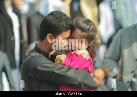 Birmingham, UK. 6 juillet, 2016. Un jeune homme asiatique britannique détient une jeune fille dans ses bras avec affection familiale ou l'amour. Banque D'Images