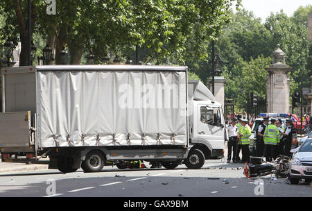 Les services d'urgence assistent aux scènes d'un accident impliquant une moto de police et un camion à la porte de Buckingham, dans le centre de Londres. Banque D'Images