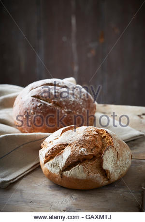 Deux pains de boulangerie artisanale sur fond sombre avec tissu en lin Banque D'Images
