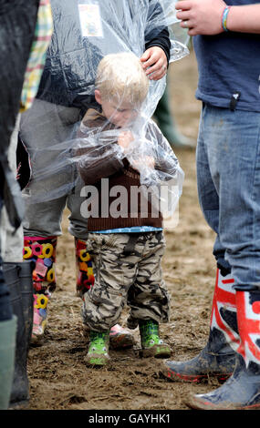 Un jeune garçon se protège de la pluie pendant le Glastonbury de 2008 Festival Banque D'Images