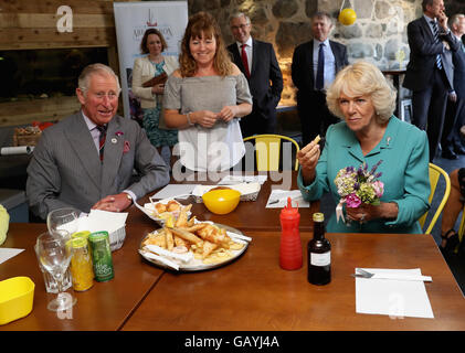 Le Prince de Galles et la duchesse de Cornouailles sont servis du poisson et des frites dans le village d'Aberdaron le deuxième jour de leur visite d'été annuel au Pays de Galles. Banque D'Images