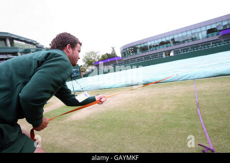 Tennis - Championnat de Wimbledon 2008 - neuvième jour - le All England Club.Le personnel au sol tire les couvertures tandis que la pluie légère tombe pendant les championnats de Wimbledon 2008 au All England tennis Club de Wimbledon. Banque D'Images