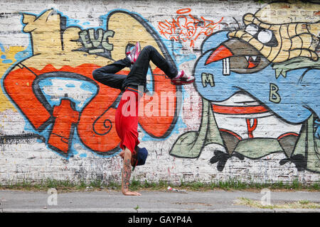 Un spectacle d'HipHop danseur en face d'un mur de graffiti. Banque D'Images