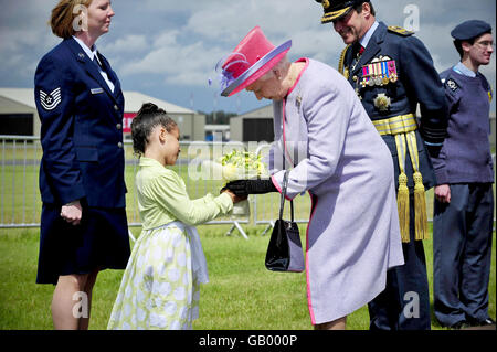 La reine Elizabeth II de Grande-Bretagne accepte des fleurs de Soleece Anabwani, 6 ans, à la RAF Fairford, après avoir présenté les nouvelles couleurs de la reine conjointement à la RAF au Royaume-Uni et au Royal Air Force Regiment, à l'ouverture du Royal International Air Tattoo. Banque D'Images