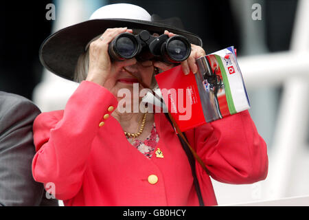 Un Spectator regarde l'action à travers ses jumelles Banque D'Images