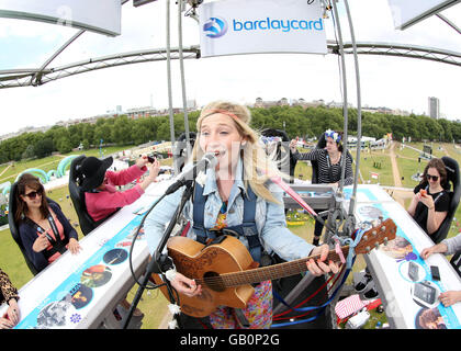 Utilisez uniquement rédactionnel Fans watch Charlotte Campbell comme elle busker effectue 100ft au-dessus du sol sur le Betterview la plate-forme à l'heure d'été britannique Barclaycard événement dans Hyde Park, Londres. Banque D'Images