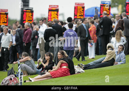 Courses hippiques - Girls Aloud Music Night - Sandown Park.Les Racegoers prennent une pause pendant la soirée musicale des filles à haute voix à l'hippodrome de Sandown Park. Banque D'Images