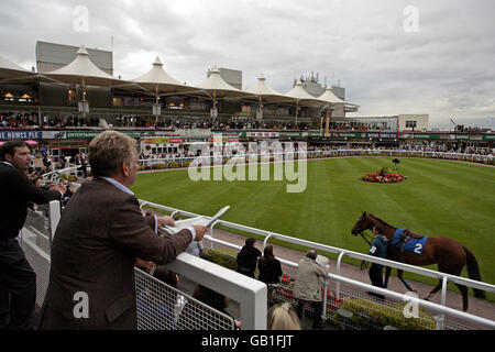 Courses hippiques - Girls Aloud Music Night - Sandown Park.Les Racegoers regardent les chevaux se diriger autour de l'anneau de parade, pendant la soirée musicale des filles à haute voix à l'hippodrome de Sandown Park. Banque D'Images