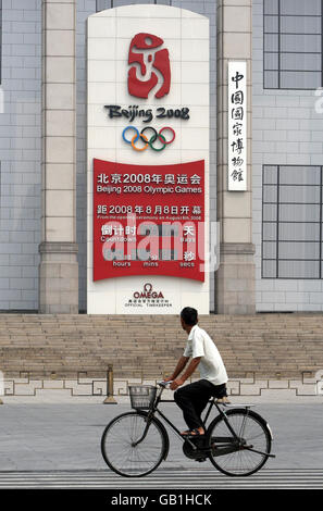 Un cycliste passe un panneau avec un compte à rebours pour les Jeux Olympiques de 2008, au Musée national de Chine sur la place Tiananmen à Beijing, en Chine. Banque D'Images