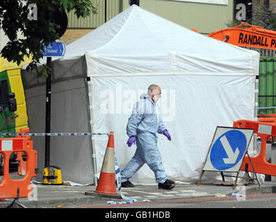 Des officiers de police judiciaire sur les lieux d'un à Cable Street, Limehouse, est de Londres où un jeune homme est mort. Banque D'Images