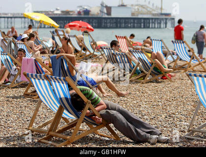 Les amateurs de plage apprécient le temps chaud sur le front de mer de Brighton. Banque D'Images