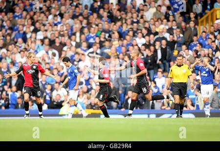 David Dunn de Blackburn Rovers célèbre le passé un abattu Mikel Arteta d'Everton après avoir inscrit le premier but avec les coéquipiers Morten Gamst Pedersen (l) et Steven Reid (3e r) le capitaine d'Everton, Phil Neville, est abattu (r) Banque D'Images