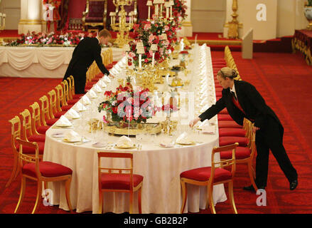 Les membres du personnel ont posé la table du banquet national, dans la salle de bal de Buckingham Palace, à Londres, avant l'ouverture estivale de la maison royale au public. Banque D'Images