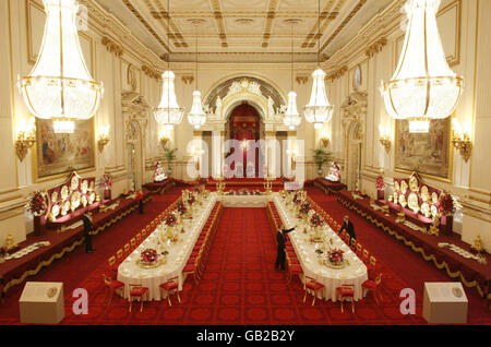 Les membres du personnel ont posé la table du banquet national, dans la salle de bal de Buckingham Palace, à Londres, avant l'ouverture estivale de la maison royale au public. Banque D'Images