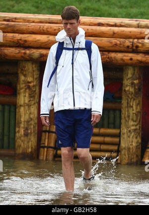 William Fox-Pitt, de l'équipe de trois jours de Grande-Bretagne, qui s'éveille au saut en eau tout en marchant sur le parcours sous une forte pluie au Beas River Equestrian venue, à Hong Kong. Banque D'Images