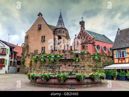 Saint-léon fontaine et maisons à colombages traditionnelles à Eguisheim, Alsace, France Banque D'Images