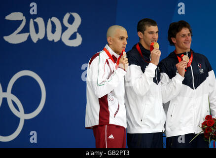 Michael Phelps (au centre), lauréat de la médaille d'or des États-Unis, célèbre après avoir remporté la victoire dans la course individuelle Medley de 200 m pour hommes aux côtés du médaillé d'argent hongrois Laszlo Cseh (à gauche) et du médaillé de bronze américain Ryan Lochtel au Centre aquatique national lors des Jeux Olympiques de Beijing en Chine en 2008. Banque D'Images