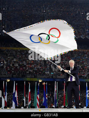 Le maire de Londres Boris Johnson fait la vague du drapeau olympique lors de la cérémonie de passation de pouvoir au stade national lors des Jeux Olympiques de Beijing en 2008, en Chine. Banque D'Images