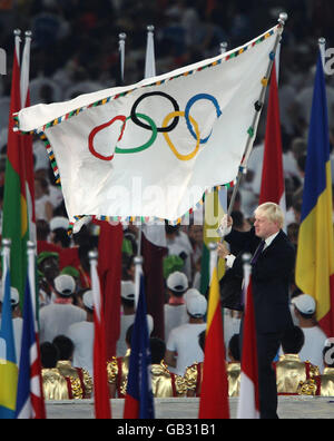 Le maire de Londres Boris Johnson fait la vague du drapeau olympique lors de la cérémonie de clôture au stade national lors des Jeux Olympiques de Beijing en 2008, en Chine. Banque D'Images