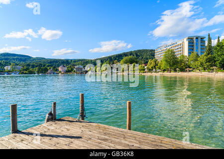 WORTHERSEE LAKE, AUTRICHE - JUN 20, 2015 : jetée en bois et bâtiment de l'hôtel le long de la rive du lac Worthersee en saison estivale. Banque D'Images