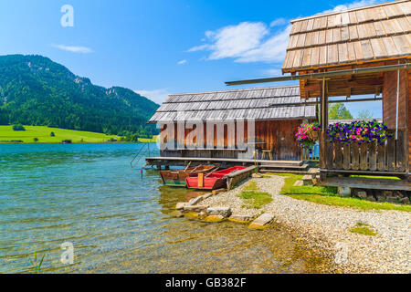 Les bateaux de pêche et les maisons en bois sur la rive du lac Weissensee en Carinthie paysage estival de terre, Autriche Banque D'Images