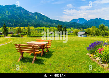 Bancs avec table de pique-nique sur l'herbe verte dans la région de alpine village sur la rive du lac Weissensee en été paysage de montagnes des Alpes, fr Banque D'Images