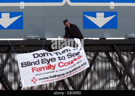 Un militant, censé être lié à Pères 4 Justice, habillé comme Batman sur un portique au-dessus de la M25 près de l'aéroport d'Heathrow, Londres. Banque D'Images