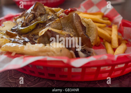 Un sale Philly Cheesesteak avec oignons poivrons et champignons, frites sur le côté Banque D'Images