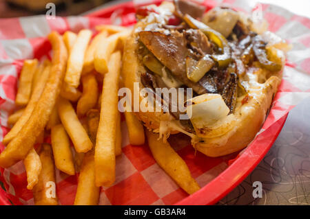 Un sale Philly Cheesesteak avec oignons poivrons et champignons, frites sur le côté Banque D'Images