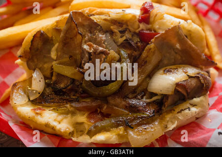 Un sale Philly Cheesesteak avec oignons poivrons et champignons, frites sur le côté Banque D'Images